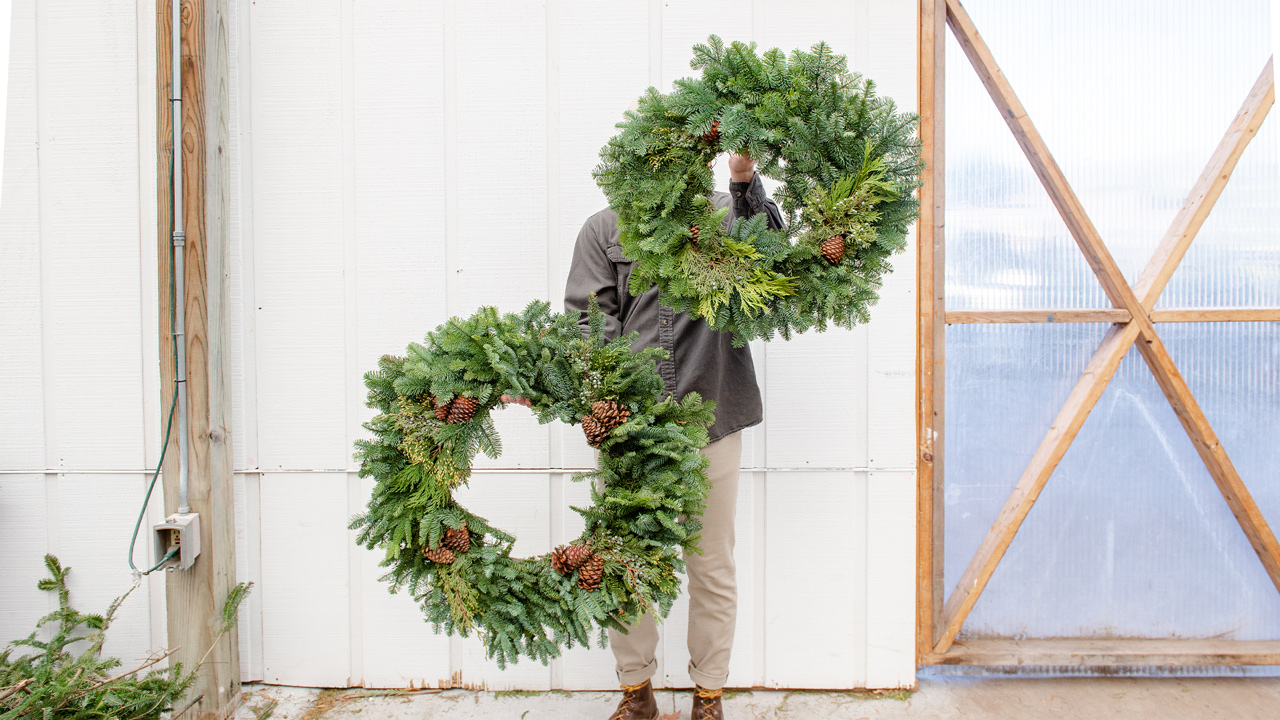 man holding christmas wreaths 